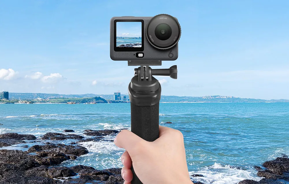 DJI camera with magnetic adapter held above seaside rocks