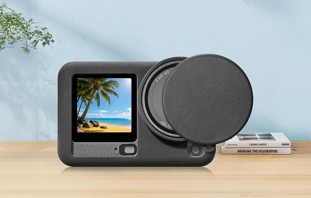 DJI Osmo Action 6 in a silicone case with open lens cover placed on a wooden surface