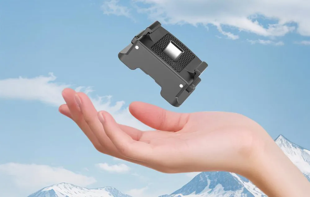A hand holding the lightweight Puluz quick-release charging adapter