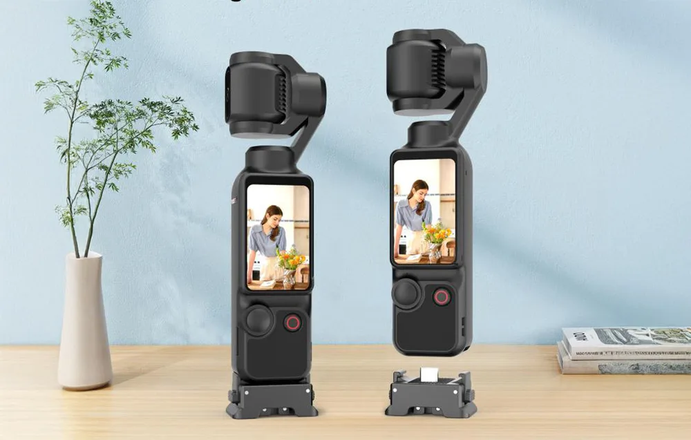 Two DJI Osmo Pocket 3 cameras with Puluz adapters placed on a wooden table next to a flower vase