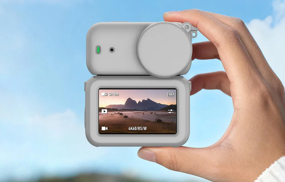 Hand holding a DJI Osmo Nano camera in a gray silicone protective case