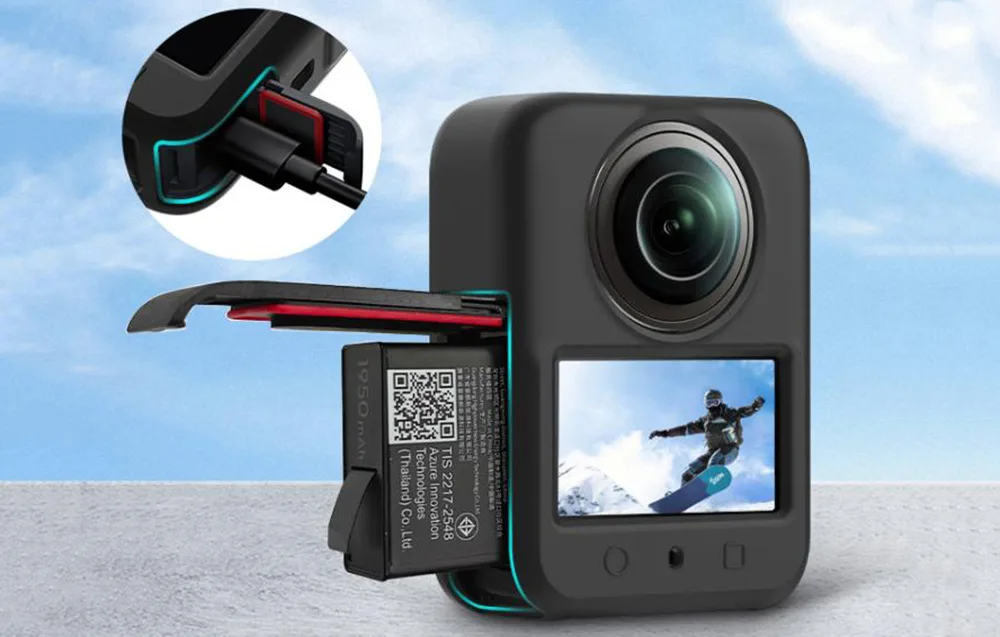 Kamera 360 stopni z obrazem snowboardzisty na ekranie i wysuniętym akumulatorem na tle nieba