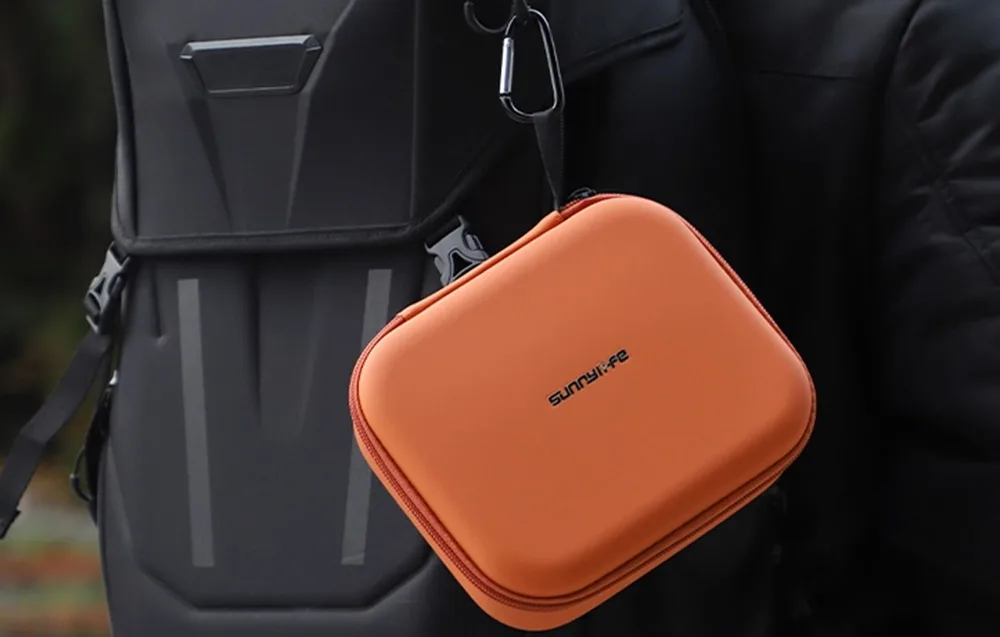 Orange Sunnylife case attached to a black backpack