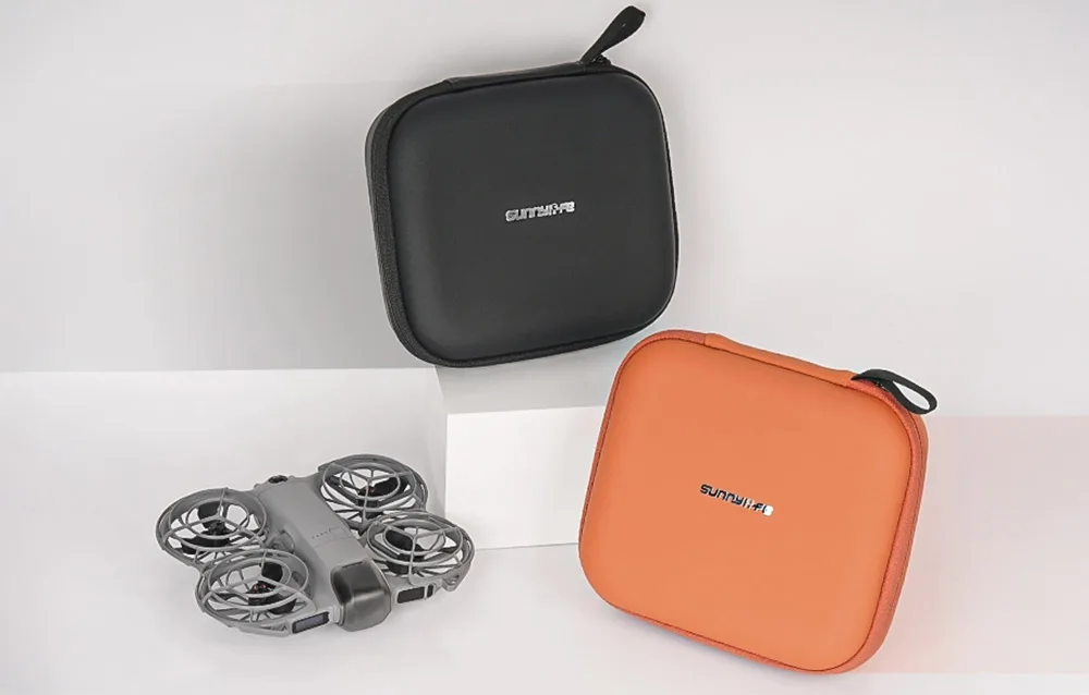 Two closed Sunnylife cases in black and orange with a drone placed next to them