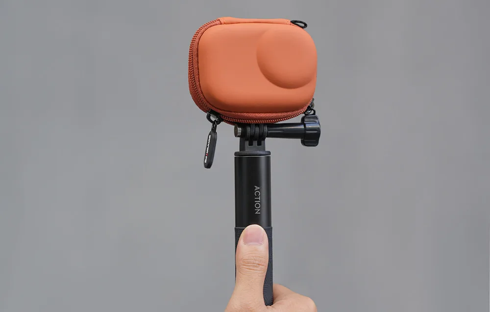 DJI Osmo Action camera on a tripod with Sunnylife orange protective case