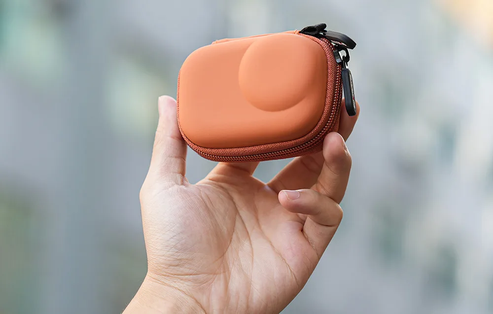 Sunnylife orange case for DJI Osmo Action camera held in hand