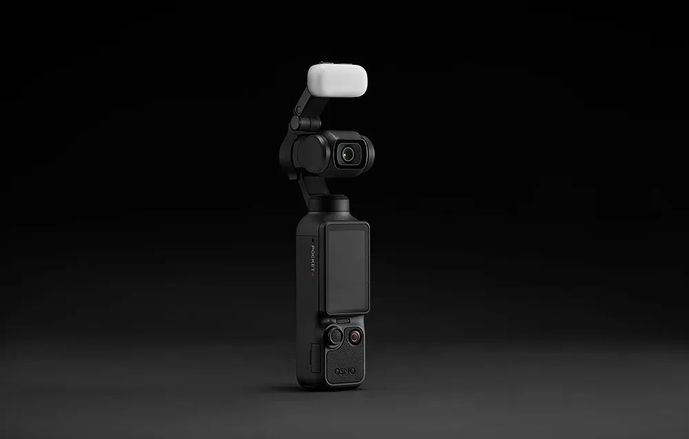 DJI Osmo Pocket 4 camera with a white fill light mounted on top against a black background