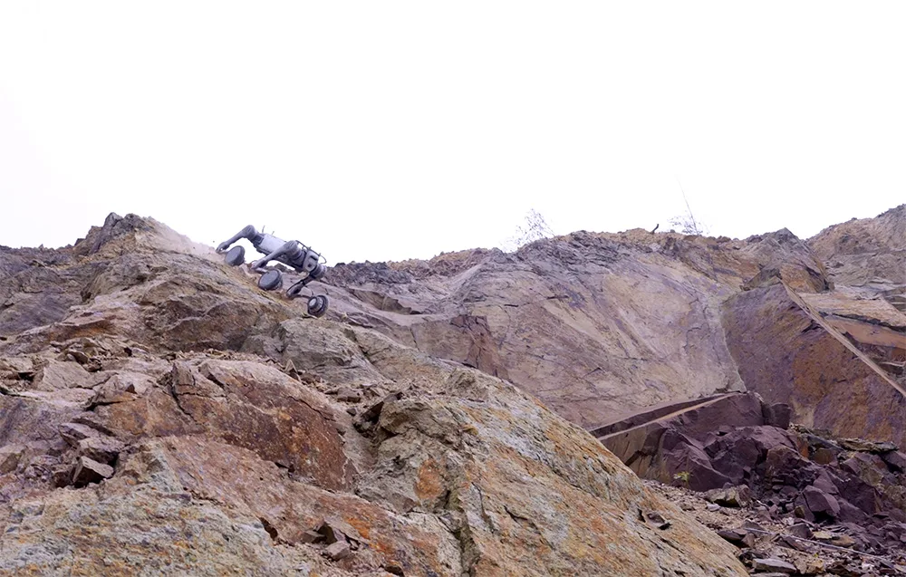 UNITREE B2-W robot climbing a steep rocky slope
