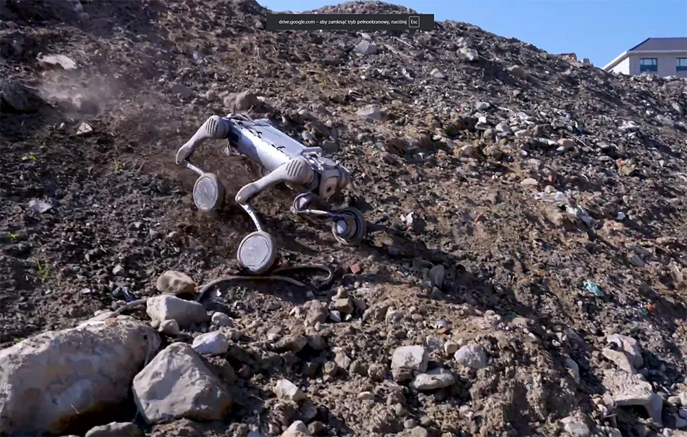 UNITREE B2-W robot moving across rocky debris-covered terrain