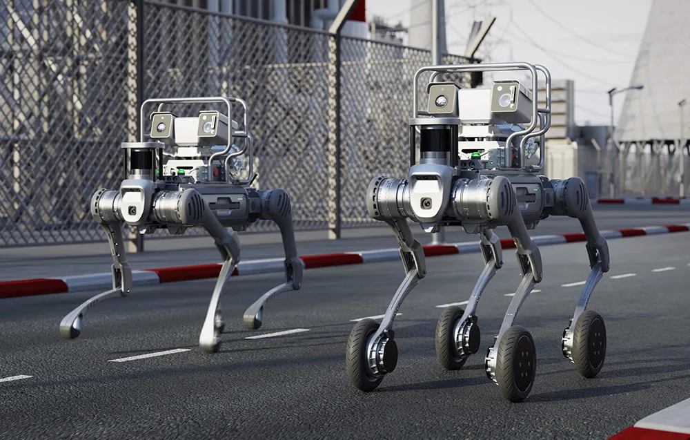 Two UNITREE B2-W quadruped robots with wheels on a street near an industrial facility