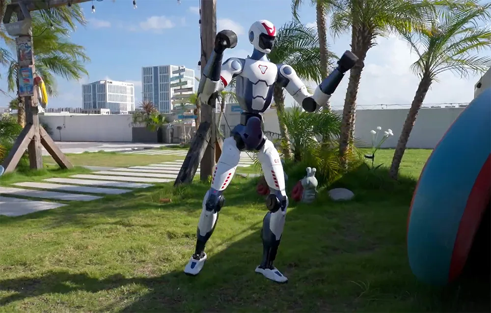 Robot humanoidalny trenujący boks na trawniku w otoczeniu palm i nowoczesnej architektury