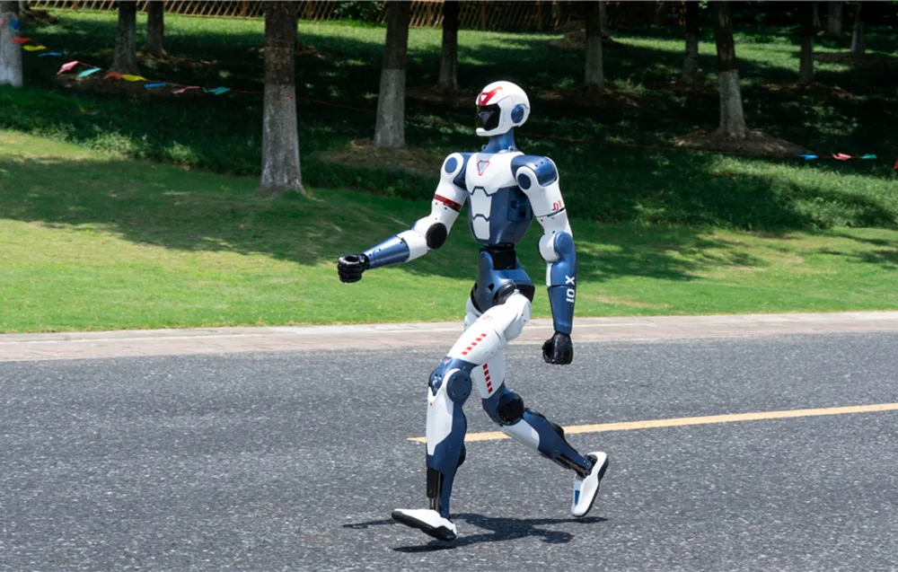 UNITREE R1 Edu U2 humanoid robot running on pavement near a green park