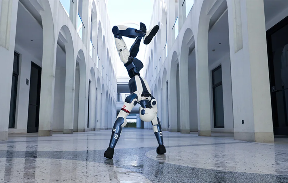 UNITREE R1 Edu U2 humanoid robot performing a handstand in a building corridor