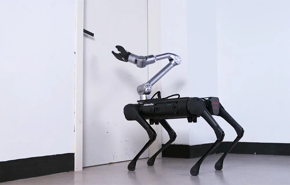 Quadruped robot with UNITREE manipulator arm standing in front of a closed door