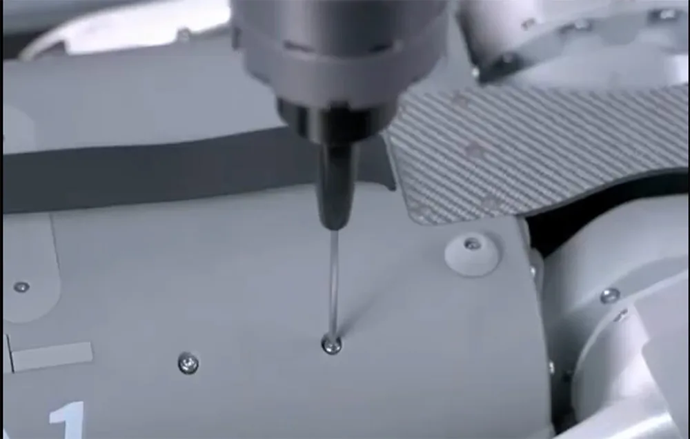 UNITREE Z1 Pro robotic arm using a screwdriver above a robot housing
