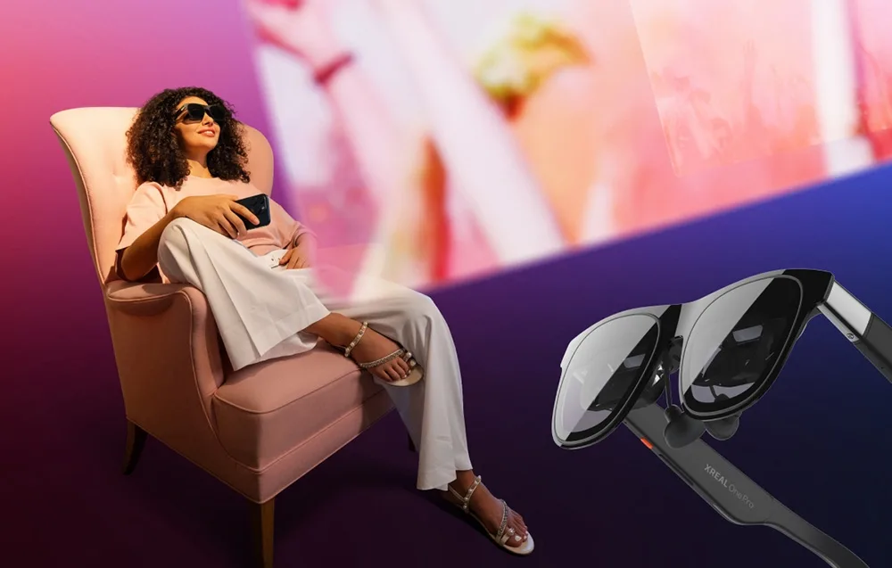 Усміхнена жінка сидить у кріслі та користується AR-окулярами XREAL One Pro
