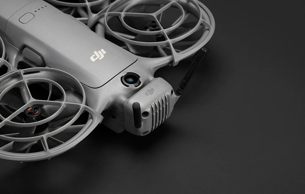 Close-up of a gray DJI drone with propeller guards and a mounted transmitter-receiver with antennas