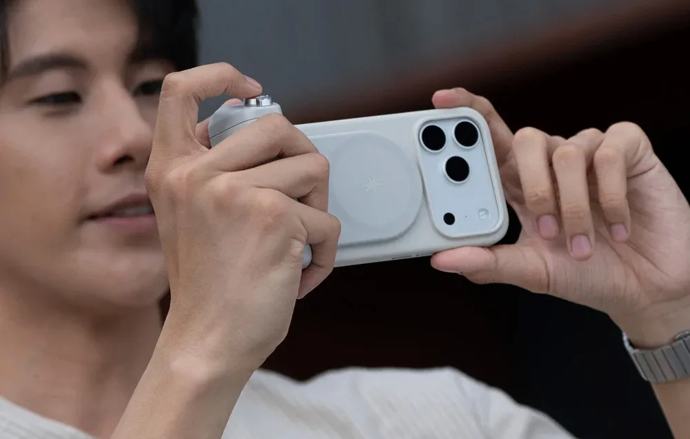 Person shooting horizontally with a smartphone attached to the PGYTech MagCam 2 grip