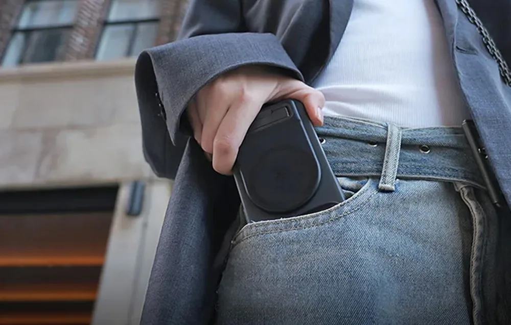 Person placing a smartphone with the PGYTech MagCam 2 grip into the front pocket of jeans