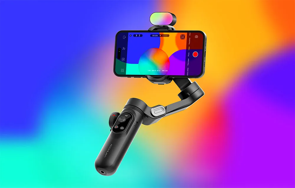 Gimbal ze smartfonem i kolorowym światłem RGB na górze zaprezentowany na intensywnym, wielobarwnym tle.