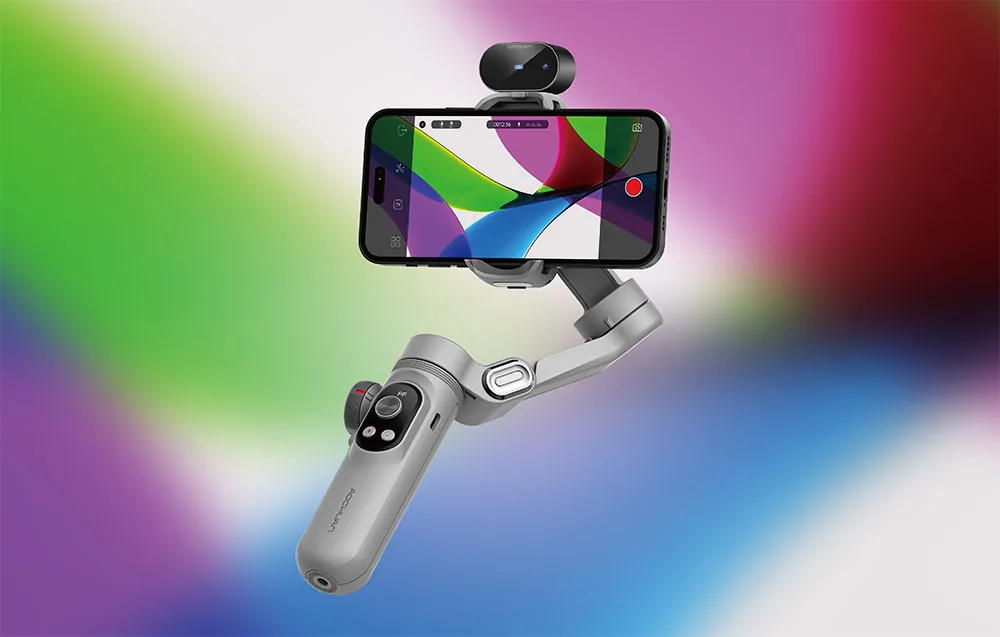 Gimbal ze smartfonem i dodatkową kamerką na górze zaprezentowany na jasnym, kolorowym tle gradientowym.