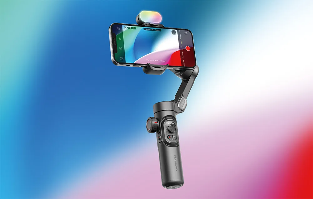 Gimbal ze smartfonem i modułem na górze zaprezentowany na niebiesko-czerwonym tle gradientowym.