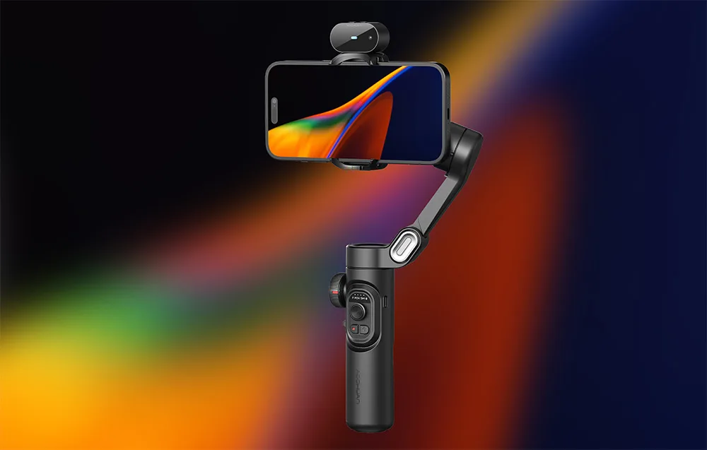 Gimbal ze smartfonem i modułem na górze zaprezentowany na ciemnym, wielokolorowym tle gradientowym.
