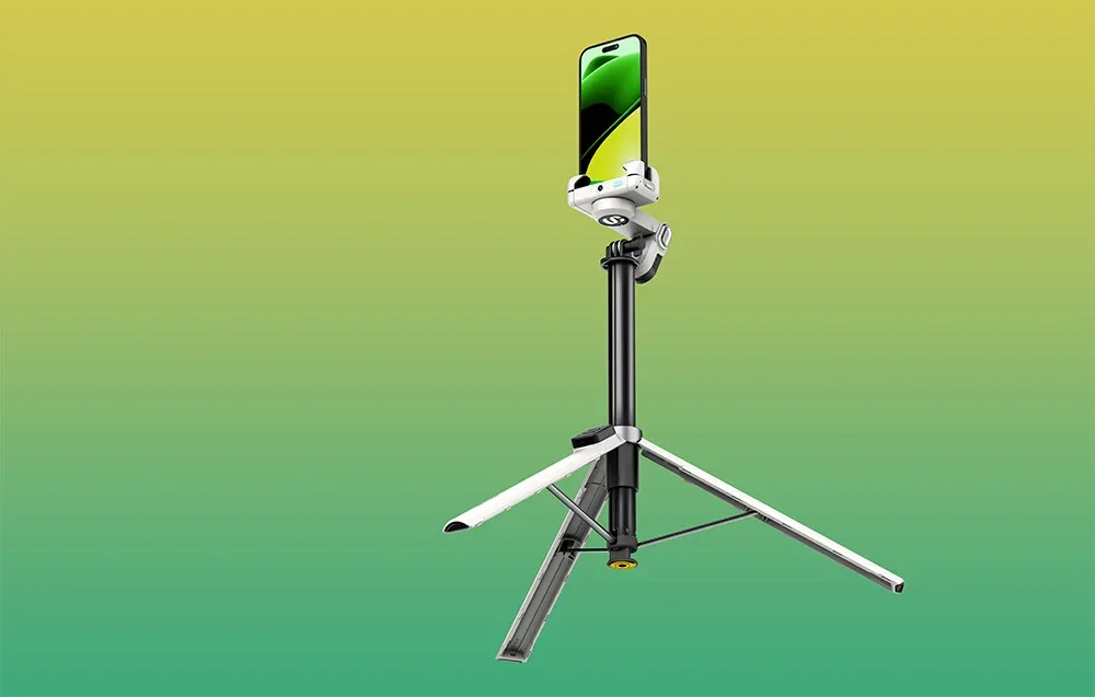 Gimbal ze smartfonem zamocowany na wysokim, rozkładanym statywie na żółto-zielonym gradientowym tle.