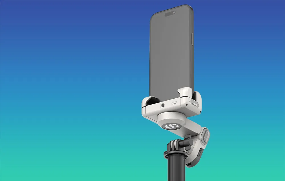 Close-up of the AOCHUAN M3 Pro Mini gimbal handle with a smartphone mounted vertically on a blue turquoise background.