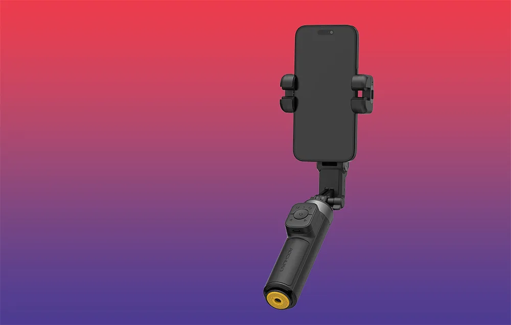 Czarny gimbal ze smartfonem w pozycji pionowej na gradientowym tle czerwono-fioletowym.