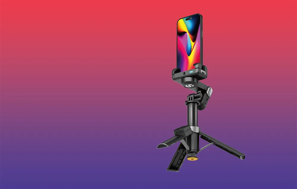 Gimbal ze smartfonem ustawiony pionowo na mini statywie na gradientowym tle czerwono-fioletowym.
