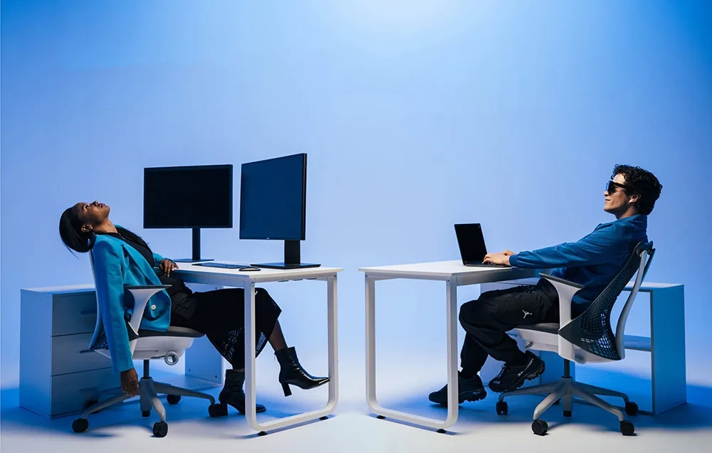 A man wearing VITURE XR Beast glasses works at a desk in a modern blue-toned workspace.