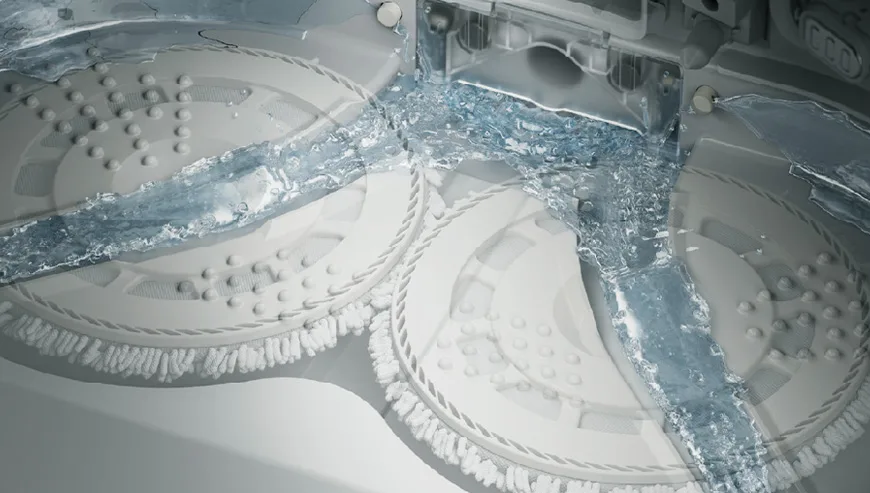 Close-up of the DJI Romo cleaning system with rotating mop pads and visible water flow