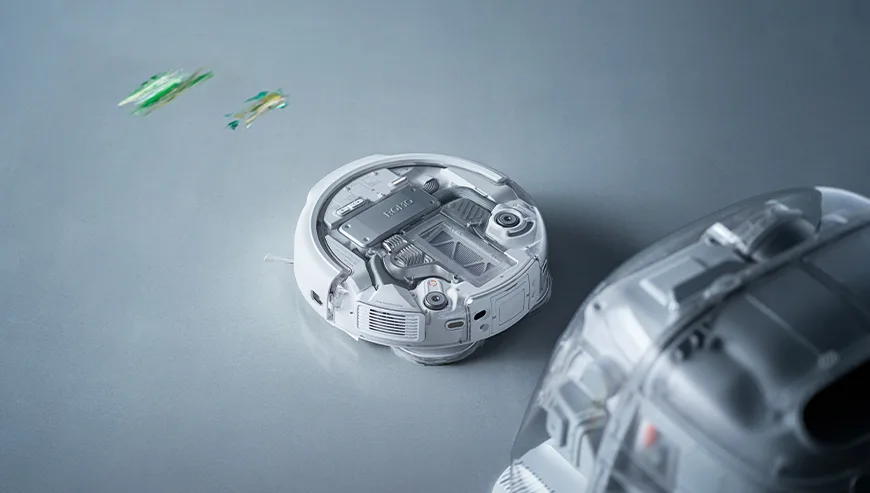 DJI ROMO robot vacuum collecting dirt from the floor next to the docking station
