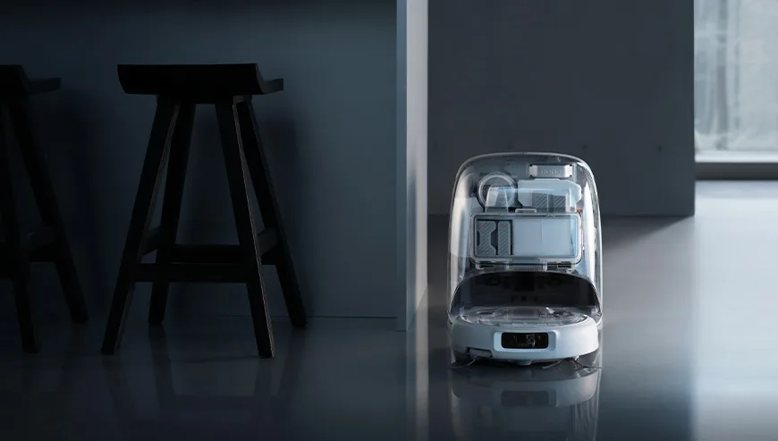 DJI ROMO docking station placed by a wall next to tall stools in a dark modern room