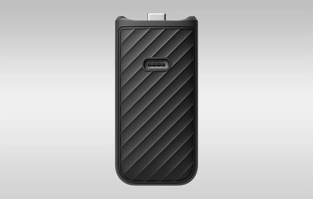 Czarny, podłużny uchwyt z ukośnymi żłobieniami posiada centralnie umieszczony port USB-C oraz wystyk USB-C na górnej krawędzi