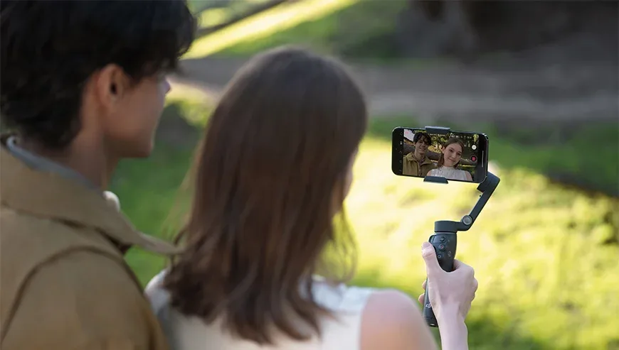 Kobieta i mężczyzna robią selfie smartfonem zamontowanym na gimbalu DJI Osmo Mobile 8